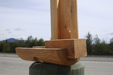 Close-up of vertical dado cuts in round house logs for precision post-and-beam construction.