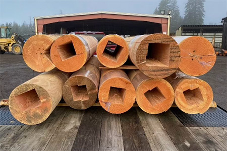 Precision-machined house logs featuring custom dado cuts for structural interlocking and post integration.