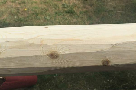 Freshly machined round house logs showing the clean finish of the machine peeling process.