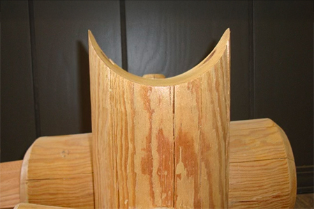 Precision-milled saddle notch joinery on round house logs for interlocking corner construction.